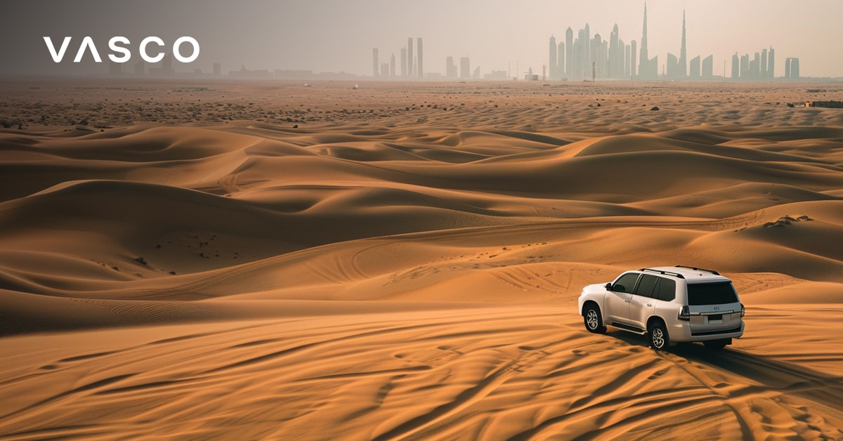 Terepjáró hajt át a Dubai-sivatagon, a távolban a város látképével