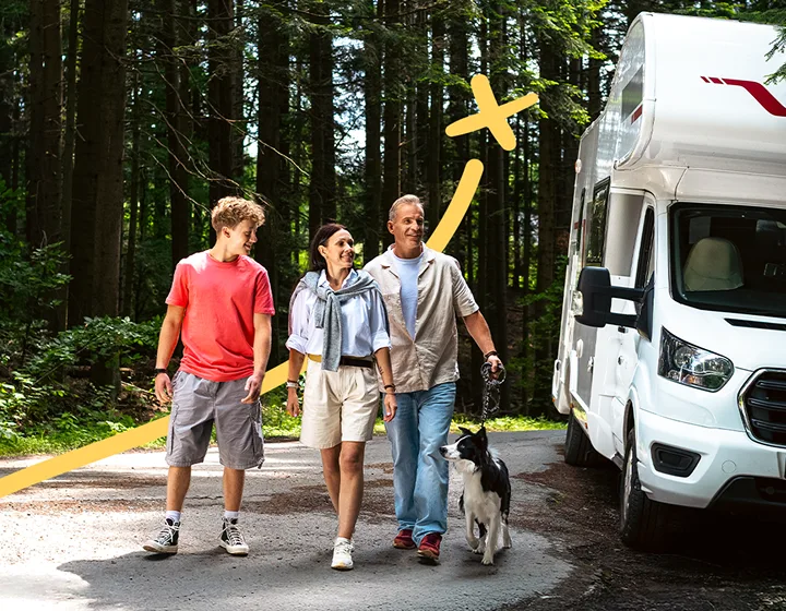 Egy háromtagú család – két szülő és egy gyermek – kutyával, amint elsétálnak a parkoló lakóautójuktól egy napsütéses napon. Mosolyognak, beszélgetnek és élvezik egymás társaságát.