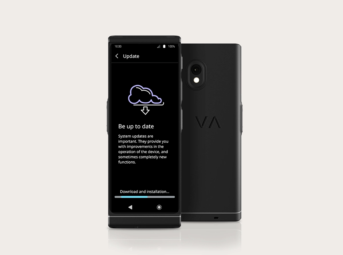 Stúdiótermékfotó a Vasco Translator V4-ről, amelyen a rendszerfrissítési felület látható. Két fekete eszköz helyezkedik el egymás mellett: az egyik előre, a másik pedig hátul néz ki. A képernyőn egy felhő ikon látható letöltési nyíllal, a „Legyen naprakész” felirattal, alul pedig egy „Letöltés és telepítés...” feliratú folyamatjelző sávval. A hátulnézetben a dupla lencsés kamera és a dombornyomott „VA” logó látható.